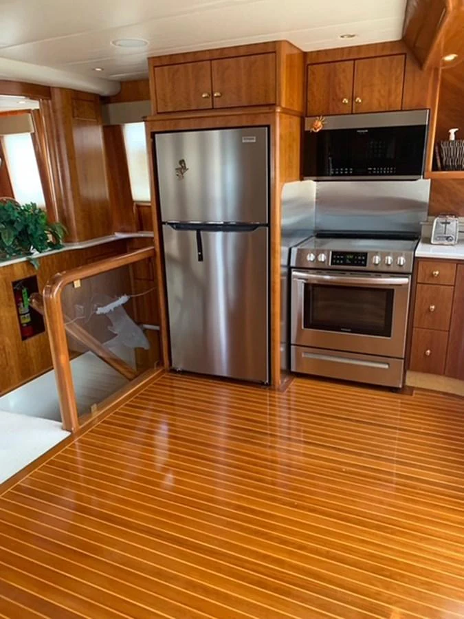The yacht's galley features modern stainless steel appliances and rich wooden cabinetry. aboard THE CAT FROM THE HAT Yacht for Sale