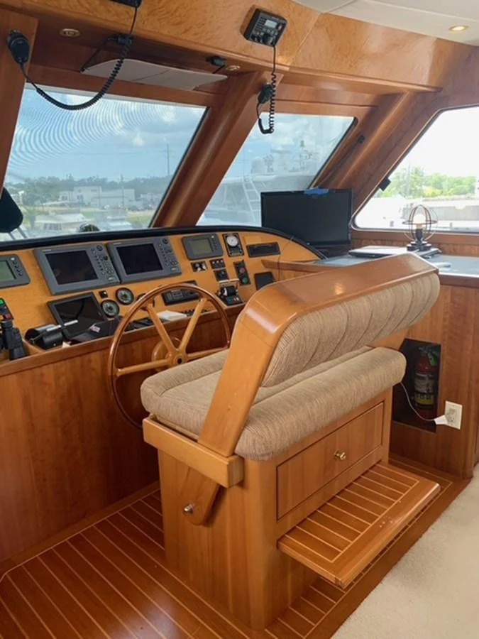 The helm features a classic wooden steering wheel and advanced navigation equipment, offering a blend of traditional and modern elements. aboard THE CAT FROM THE HAT Yacht for Sale