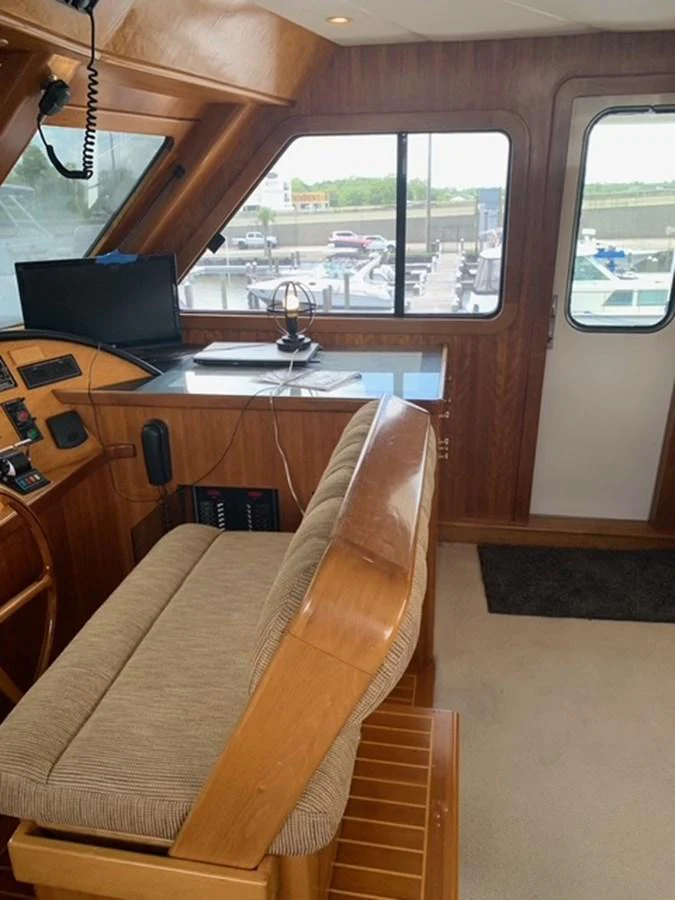 The helm station features a comfortable seating area with a clear view of the controls and navigation equipment. aboard THE CAT FROM THE HAT Yacht for Sale