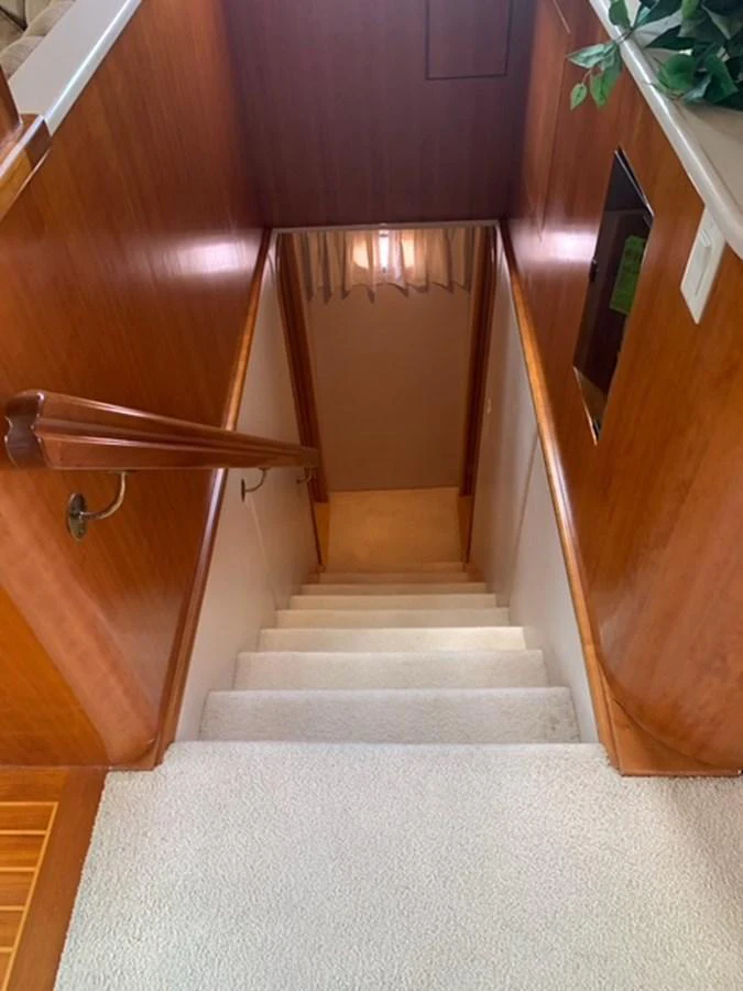 A cozy interior staircase with wooden handrails and carpeted steps leads to the lower deck. aboard THE CAT FROM THE HAT Yacht for Sale