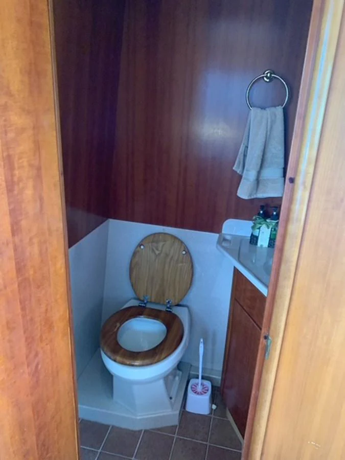 A cozy yacht head with wooden accents and essential amenities. aboard THE CAT FROM THE HAT Yacht for Sale