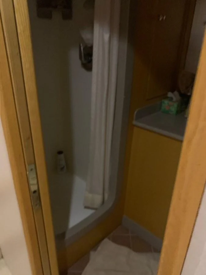 A compact yacht bathroom with a shower and a small countertop. aboard THE CAT FROM THE HAT Yacht for Sale