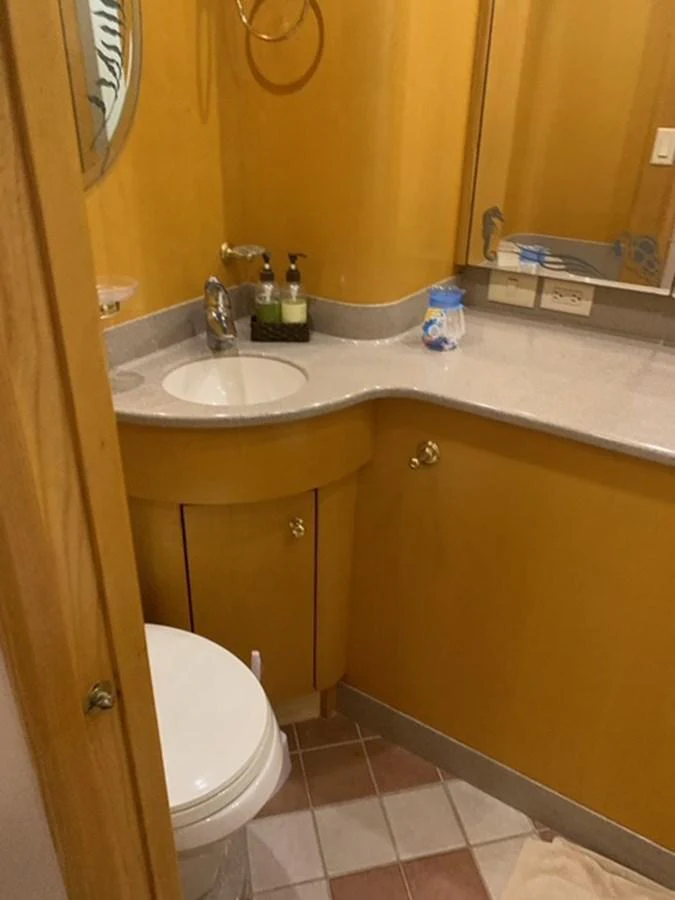 A compact and well-appointed yacht bathroom with a sink, mirror, and toilet. aboard THE CAT FROM THE HAT Yacht for Sale