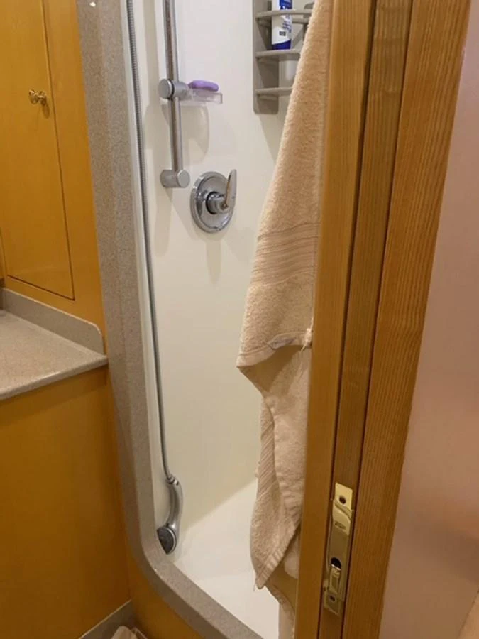 The yacht's bathroom features a compact shower area with modern fixtures and a neatly hung towel. aboard THE CAT FROM THE HAT Yacht for Sale