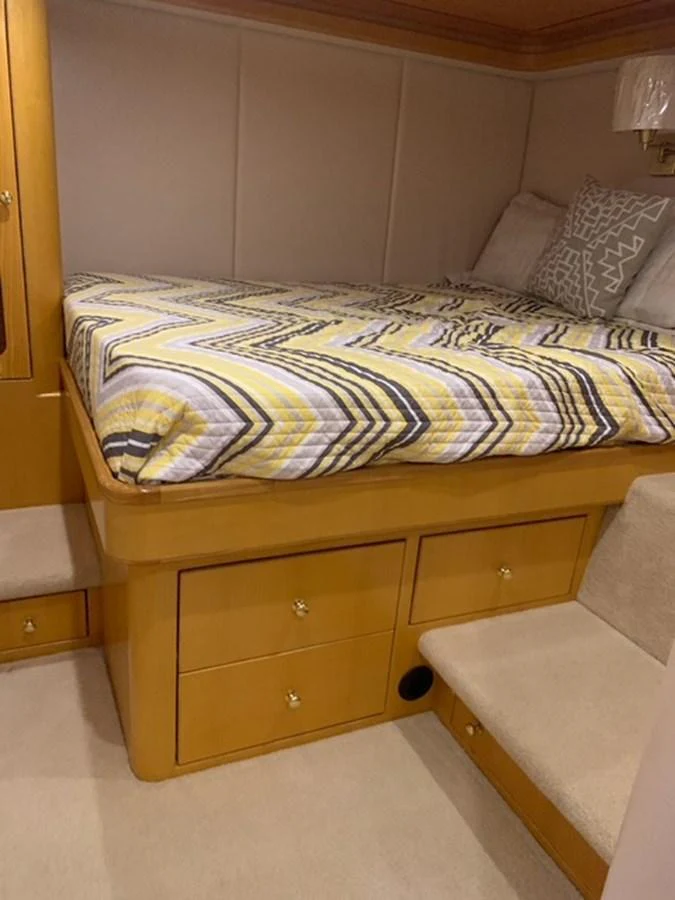 A cozy stateroom with a patterned bedspread and ample storage space. aboard THE CAT FROM THE HAT Yacht for Sale