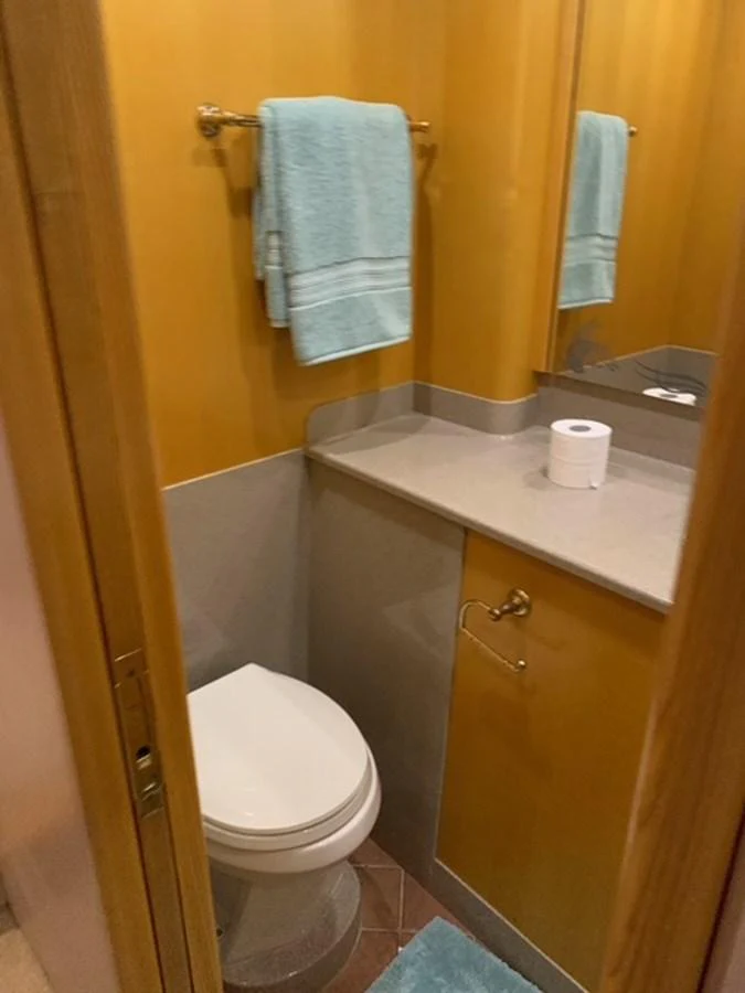 The yacht's bathroom features a clean and functional design with a modern toilet and a countertop with a mirror. aboard THE CAT FROM THE HAT Yacht for Sale