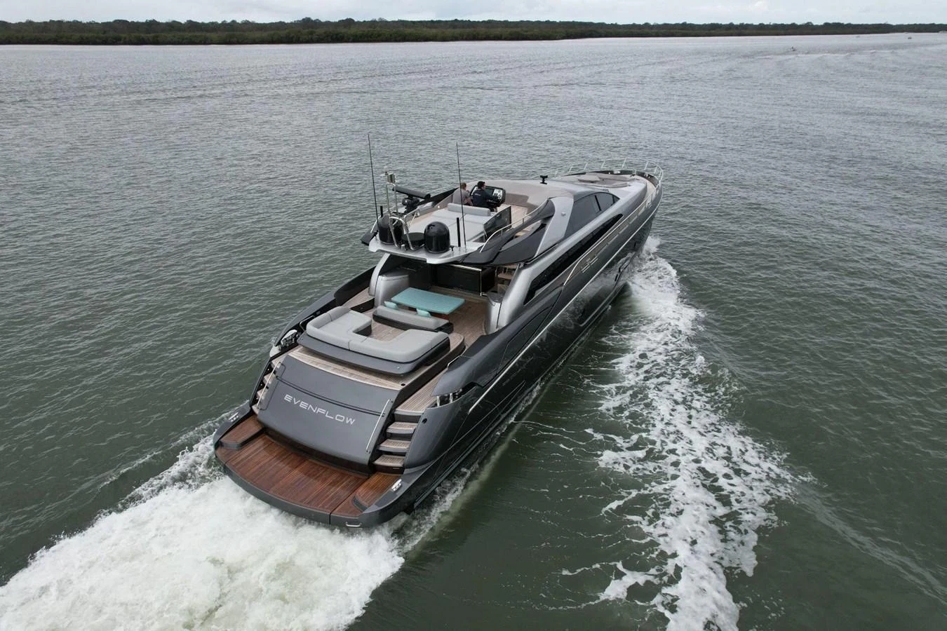A sleek and modern yacht cruises through calm waters, showcasing its luxurious aft deck and elegant design. aboard EVENFLOW Yacht for Sale