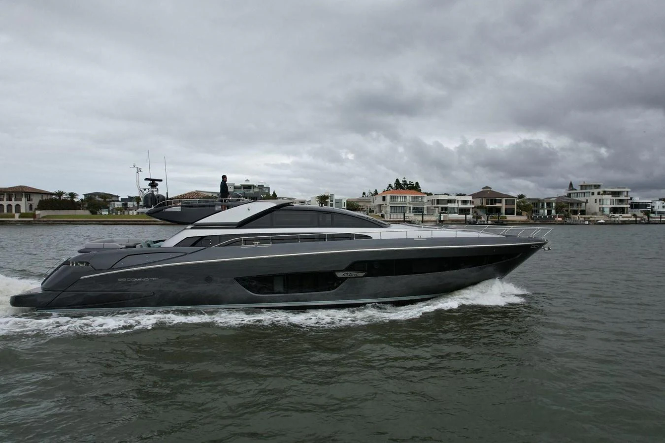 A sleek, modern yacht cruises through calm waters under a cloudy sky. aboard EVENFLOW Yacht for Sale