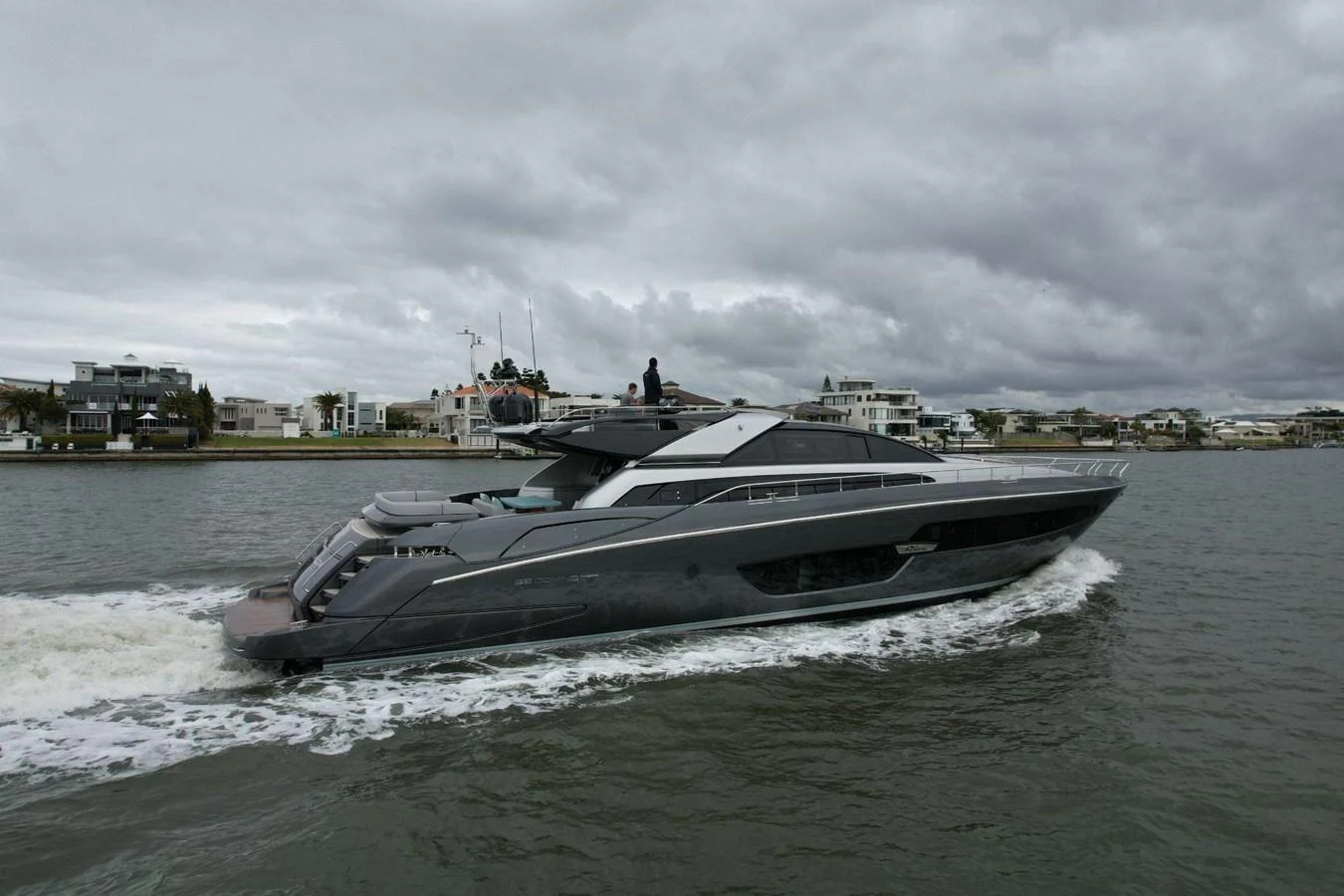 A sleek, modern yacht cruises through calm waters under a cloudy sky. aboard EVENFLOW Yacht for Sale