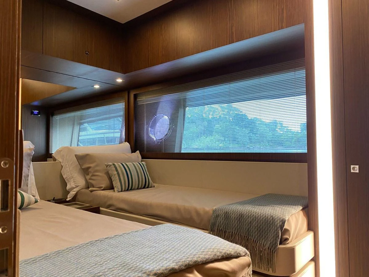 The guest stateroom offers a cozy and inviting space with twin beds and large windows providing natural light and scenic views. aboard EVENFLOW Yacht for Sale