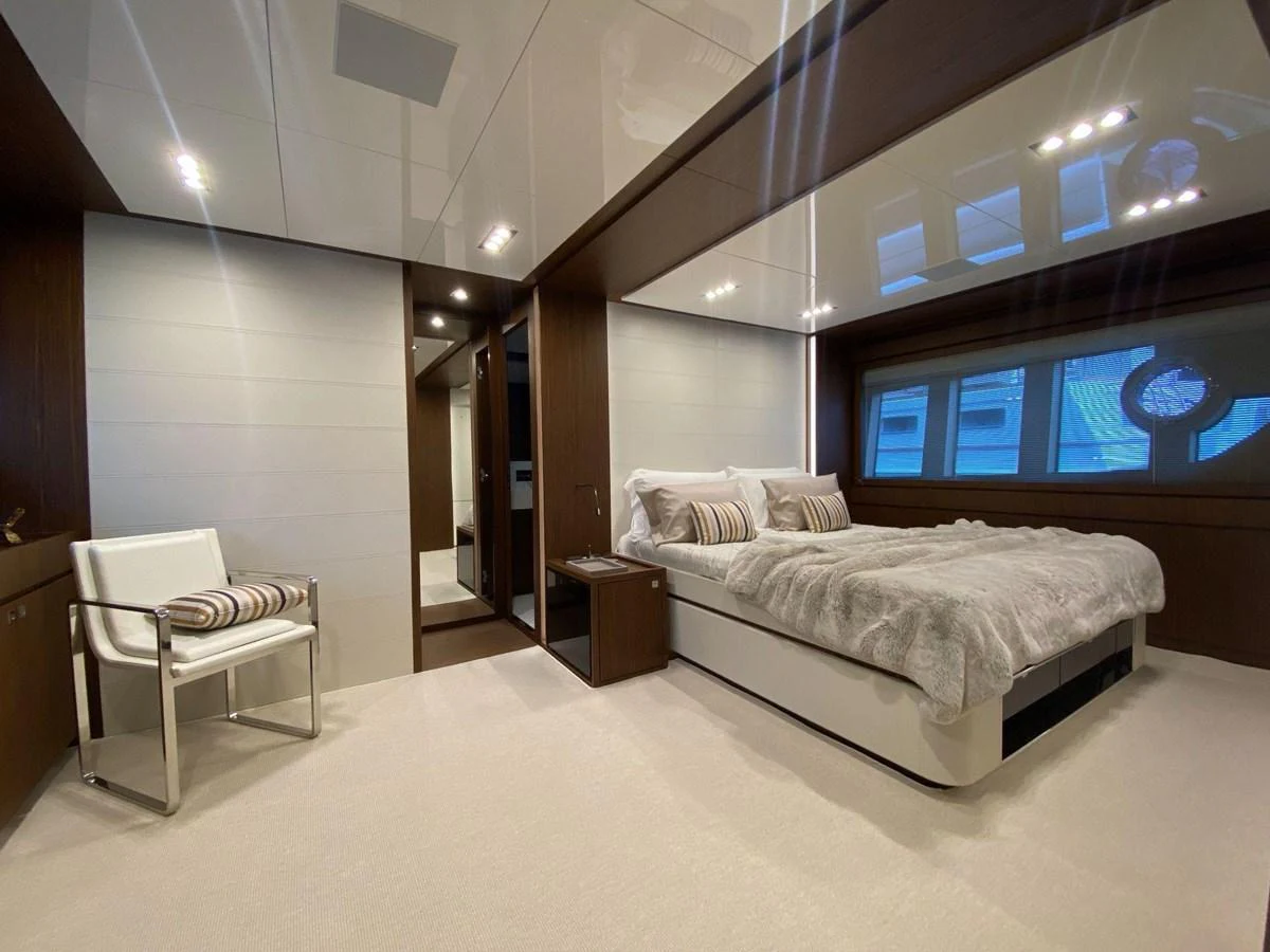 The stateroom features a luxurious bed with plush bedding, modern furnishings, and ample natural light. aboard EVENFLOW Yacht for Sale