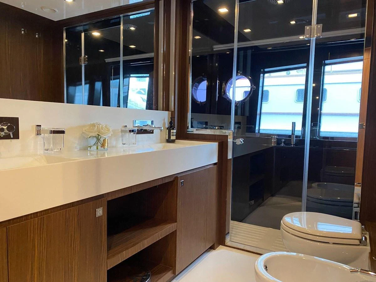 The yacht's bathroom features elegant wood finishes and modern fixtures, creating a luxurious and serene atmosphere. aboard EVENFLOW Yacht for Sale