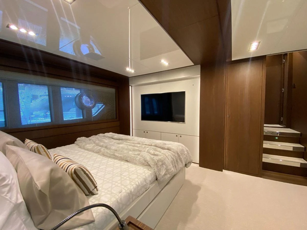 The master stateroom features a luxurious bed, modern decor, and a large flat-screen TV. aboard EVENFLOW Yacht for Sale