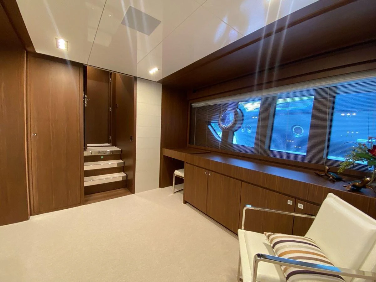 The yacht's interior features a modern, wood-paneled room with large windows and comfortable seating. aboard EVENFLOW Yacht for Sale
