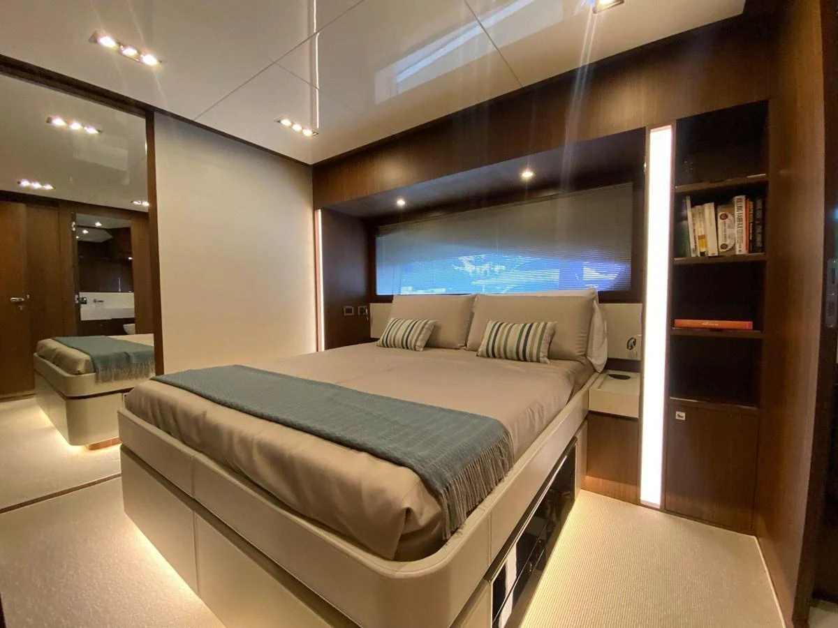 The stateroom features a luxurious bed with modern lighting and elegant wood finishes. aboard EVENFLOW Yacht for Sale