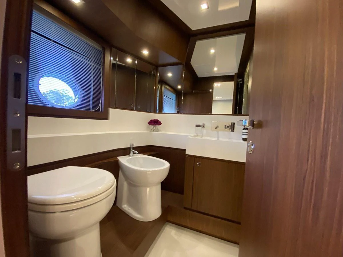 The yacht's bathroom features modern fixtures and elegant wood paneling. aboard EVENFLOW Yacht for Sale