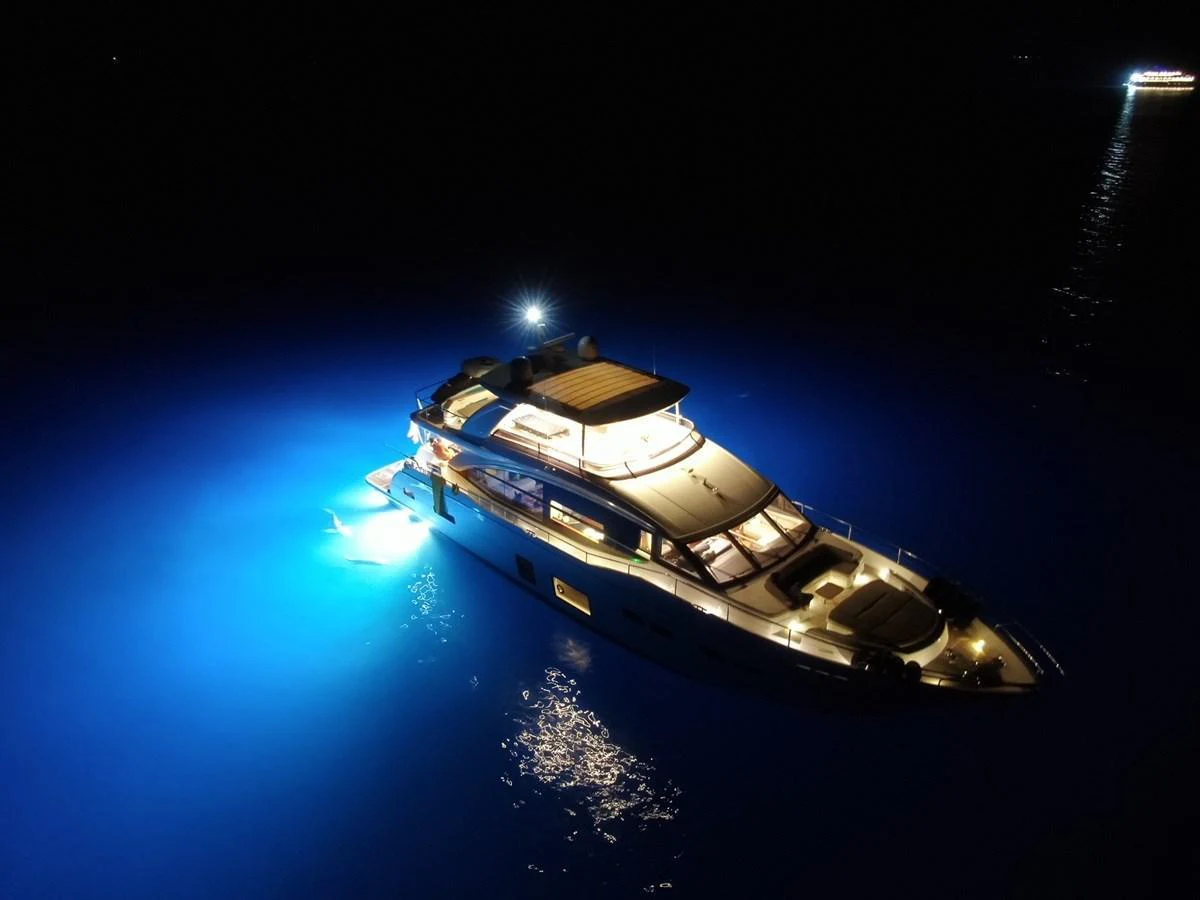 The yacht is beautifully illuminated at night, creating a stunning visual effect on the water. aboard RAGARDA Yacht for Sale