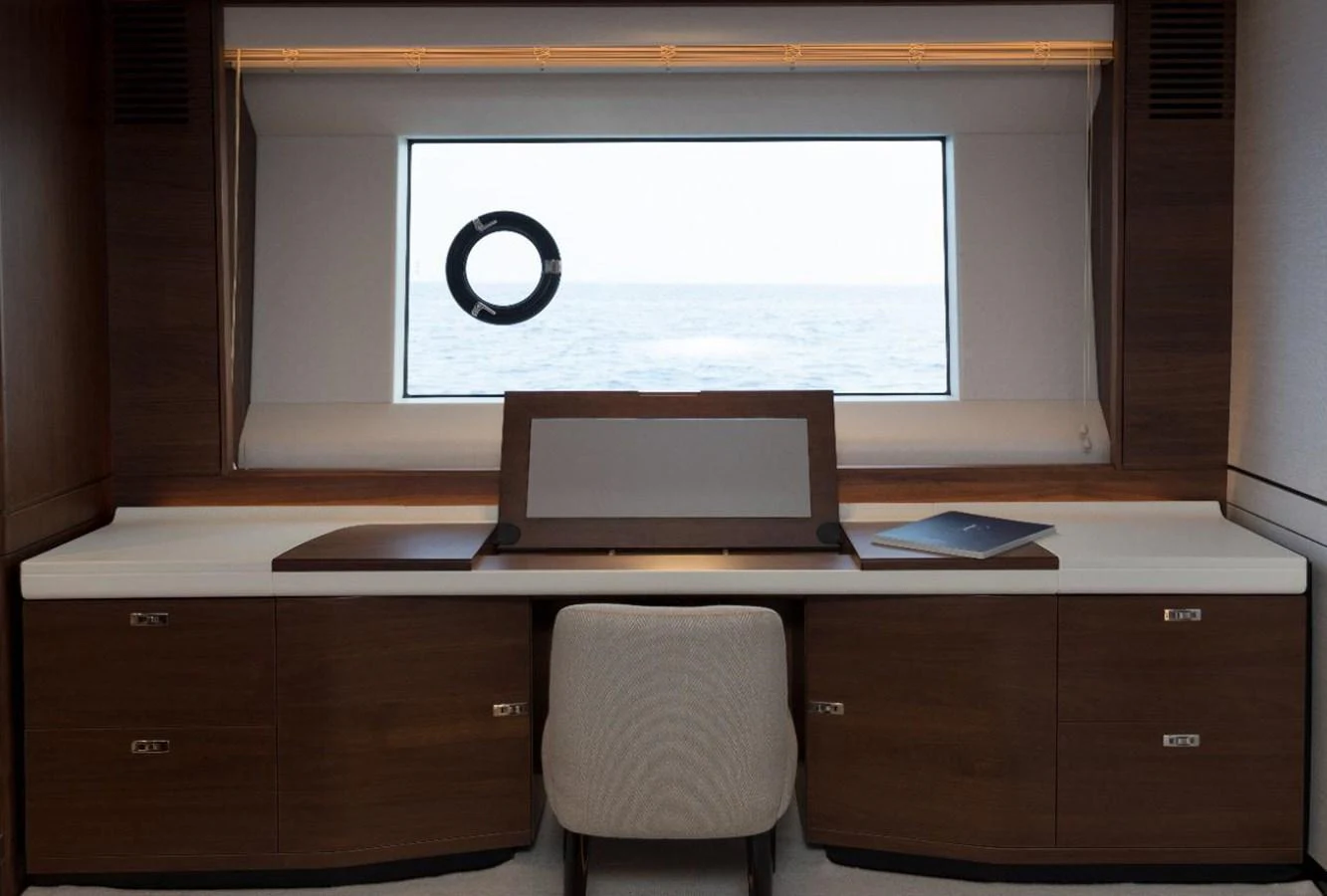 The yacht's office features a sleek desk with a view of the sea through a large window. aboard RAGARDA Yacht for Sale