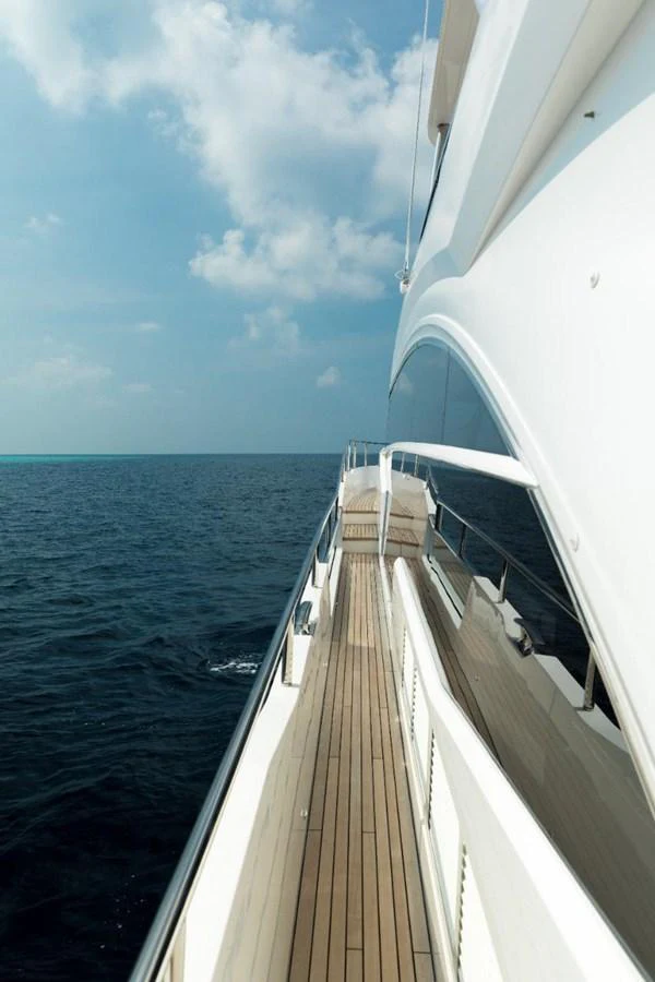A sleek side deck of a yacht with a view of the open sea and clear skies. aboard RAGARDA Yacht for Sale
