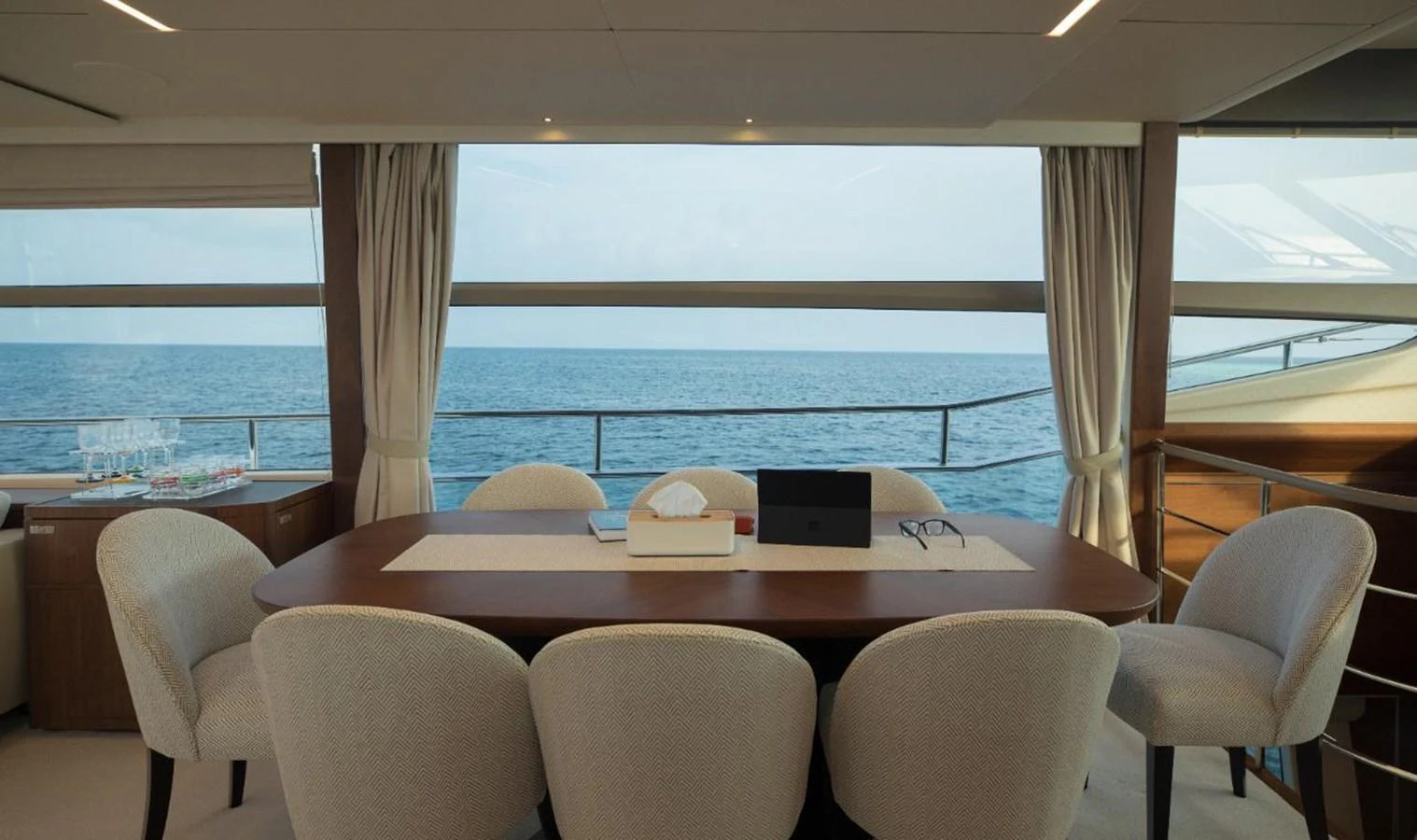The yacht's dining area offers a serene view of the ocean through large windows. aboard RAGARDA Yacht for Sale