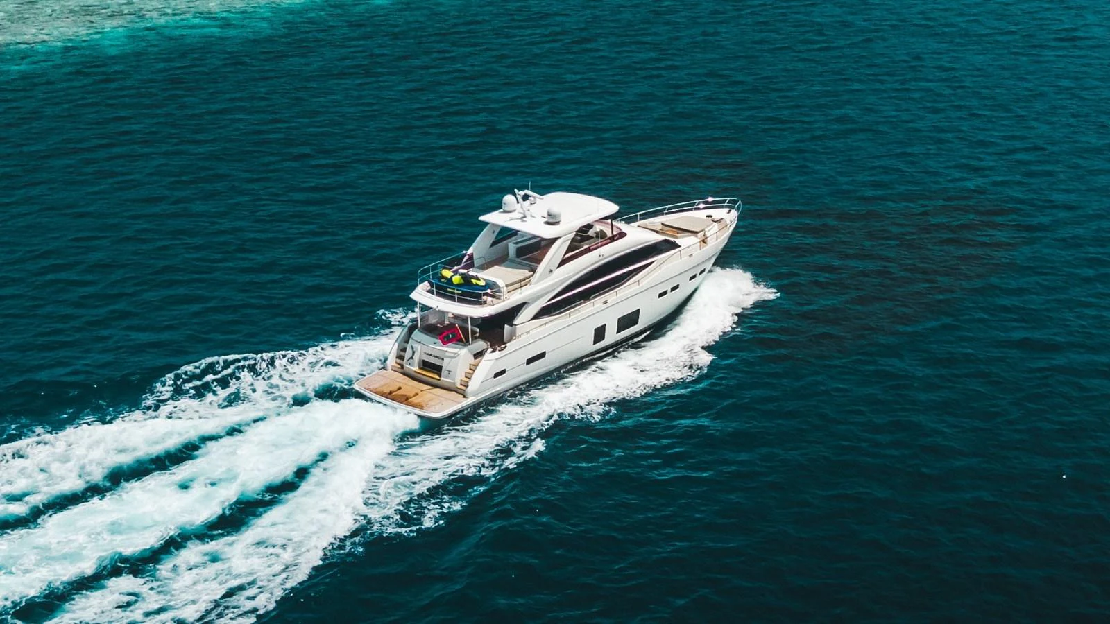 A sleek yacht cruises through clear blue waters, showcasing its elegant design and spacious deck. aboard RAGARDA Yacht for Sale