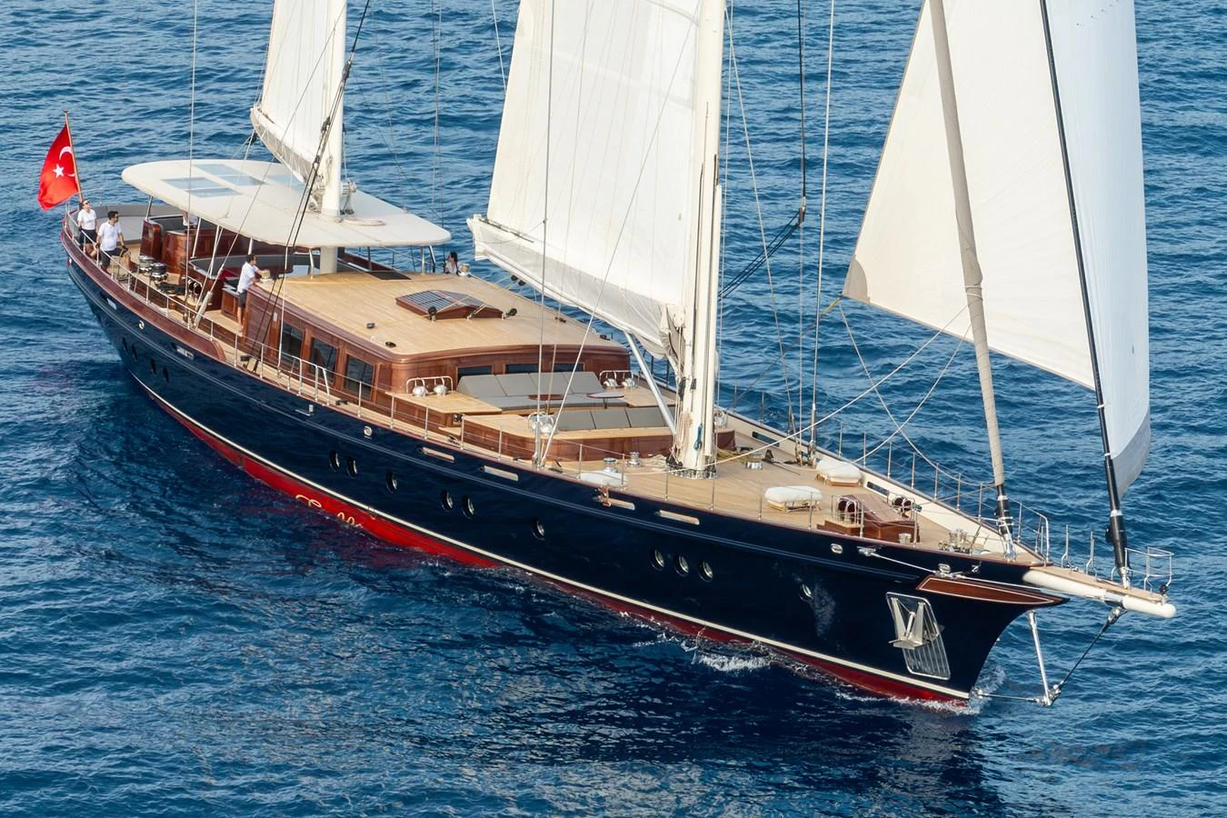 A stunning sailing yacht glides gracefully over the blue waters, showcasing its elegant design and spacious deck. aboard SALLYNA Yacht for Sale