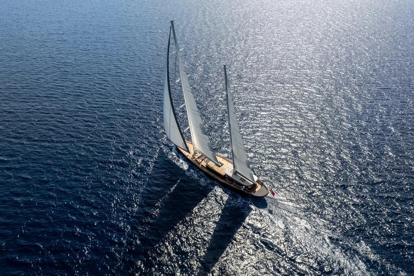 A stunning sailing yacht glides gracefully across the open sea under full sail. aboard SALLYNA Yacht for Sale
