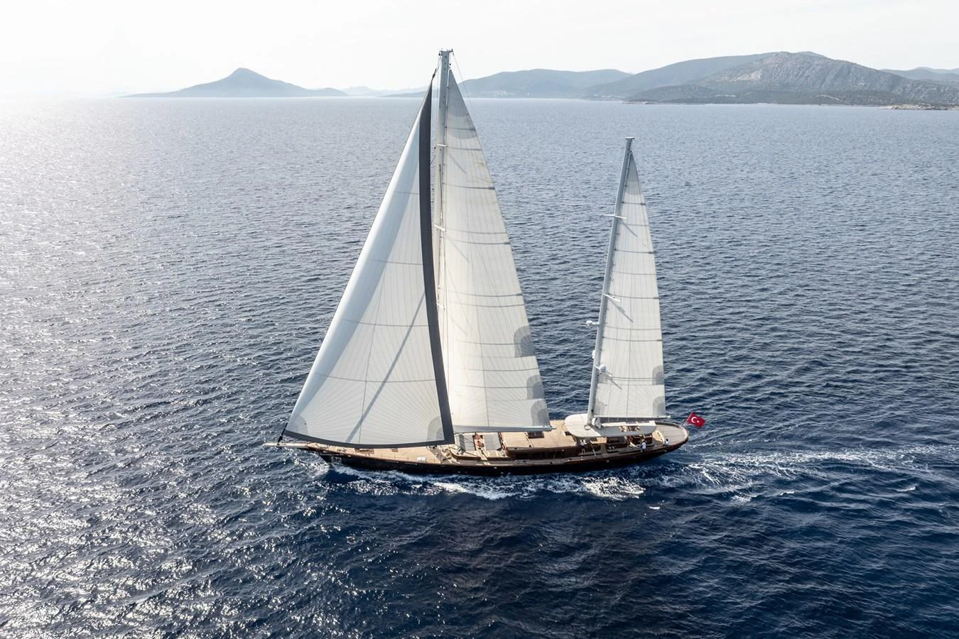 A stunning sailing yacht glides gracefully over the open sea with its sails fully unfurled. aboard SALLYNA Yacht for Sale