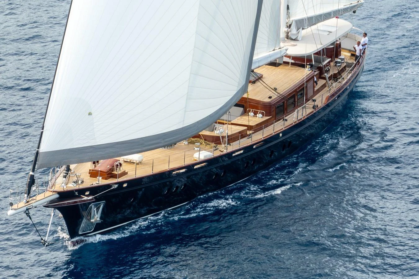 A classic sailing yacht glides gracefully on the open sea, showcasing its elegant wooden deck and billowing sails. aboard SALLYNA Yacht for Sale