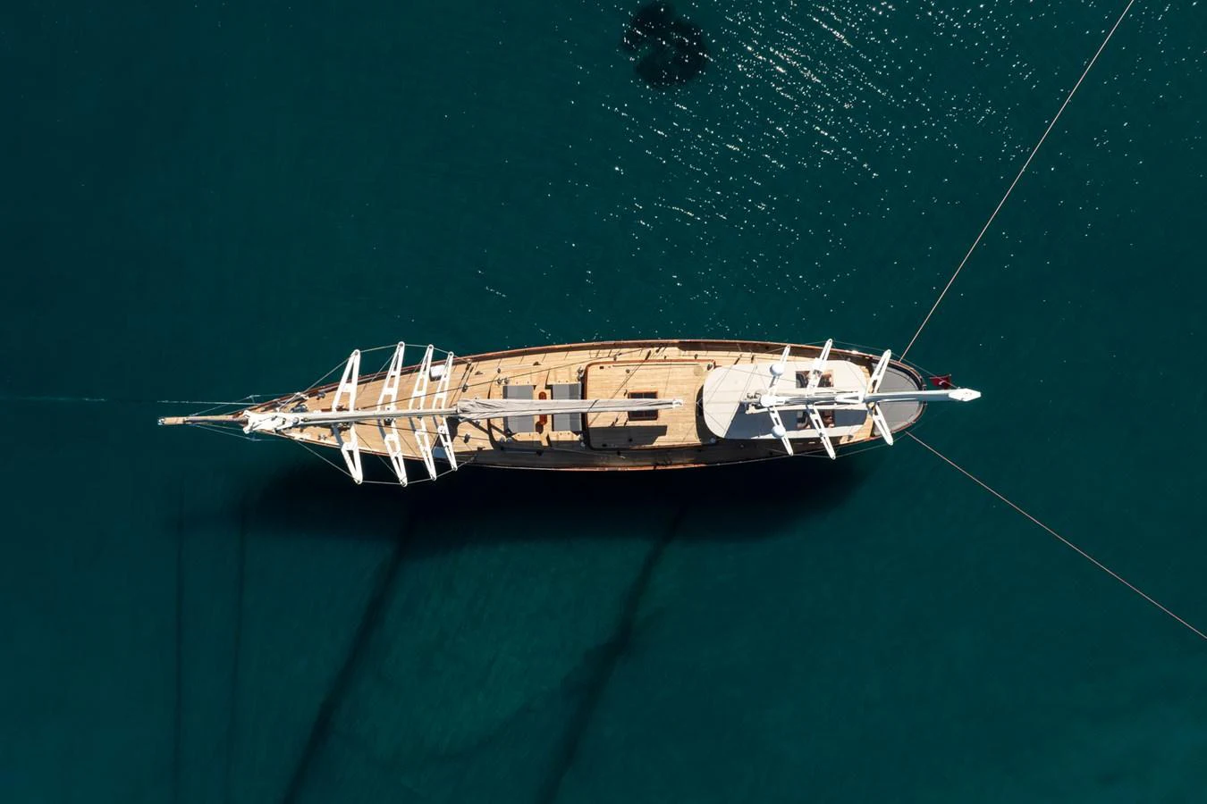 A stunning aerial view of a classic sailing yacht anchored in calm, clear waters. aboard SALLYNA Yacht for Sale