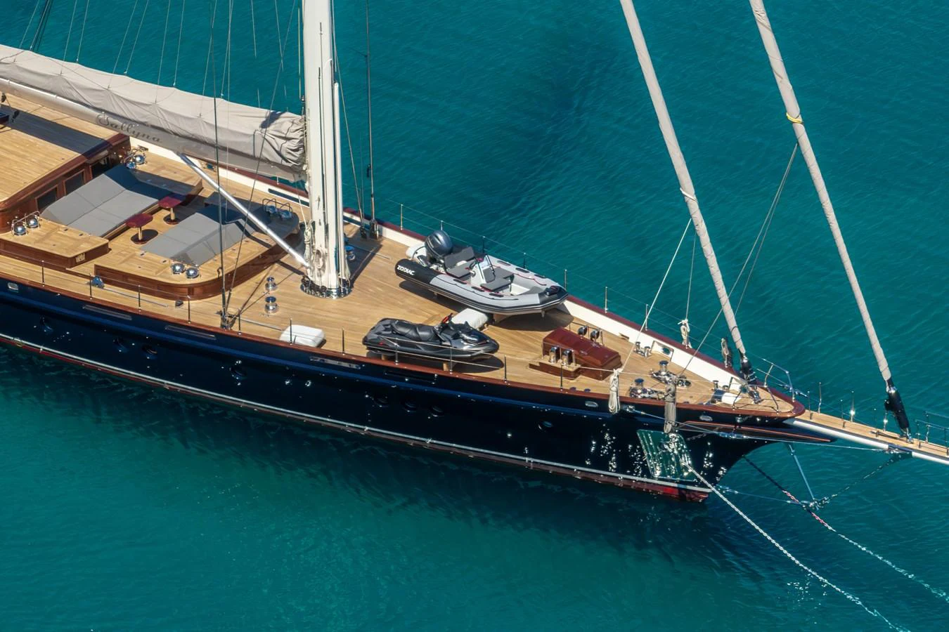 A sleek sailing yacht glides through clear blue waters, showcasing its elegant deck and luxurious amenities. aboard SALLYNA Yacht for Sale