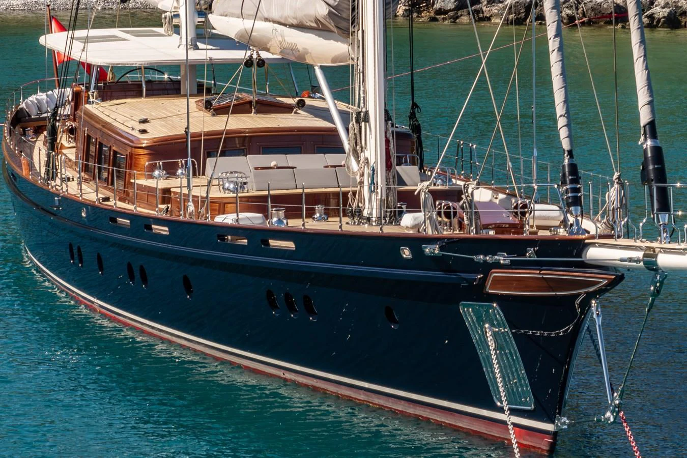 A stunning yacht with sleek lines and polished wood accents glides gracefully on the water. aboard SALLYNA Yacht for Sale