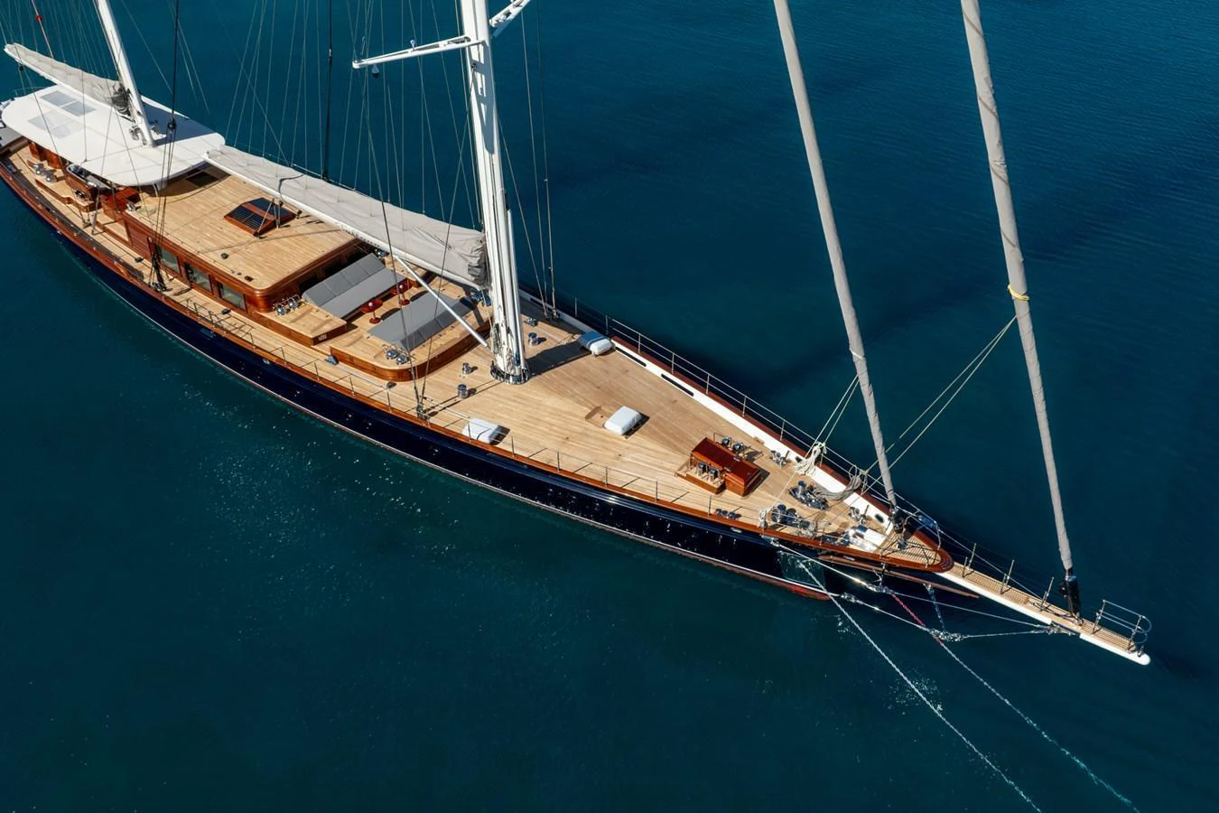 A stunning aerial view of a sleek sailing yacht gliding through calm waters. aboard SALLYNA Yacht for Sale