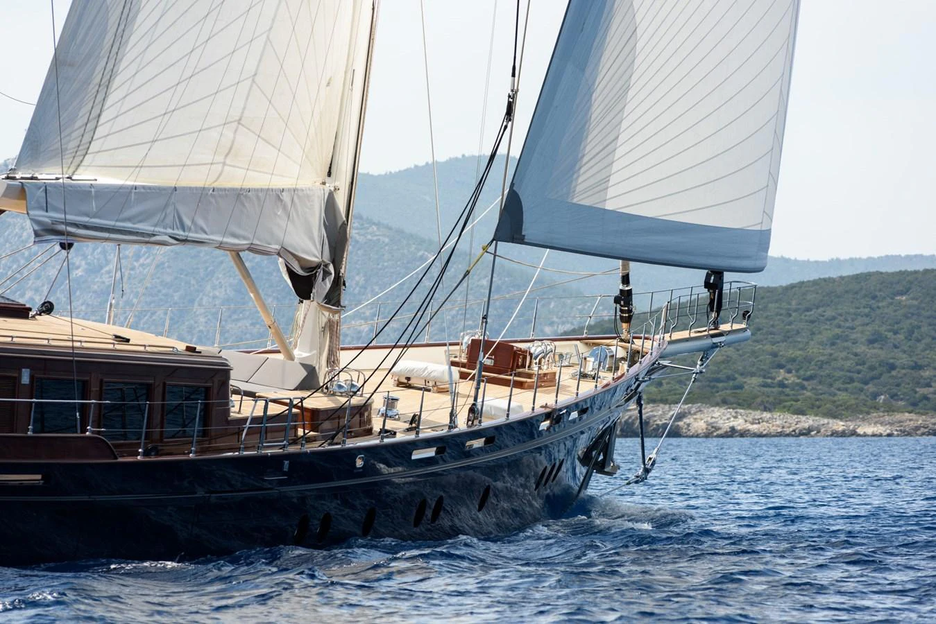 A stunning sailing yacht glides through the water with its sails fully extended. aboard SALLYNA Yacht for Sale