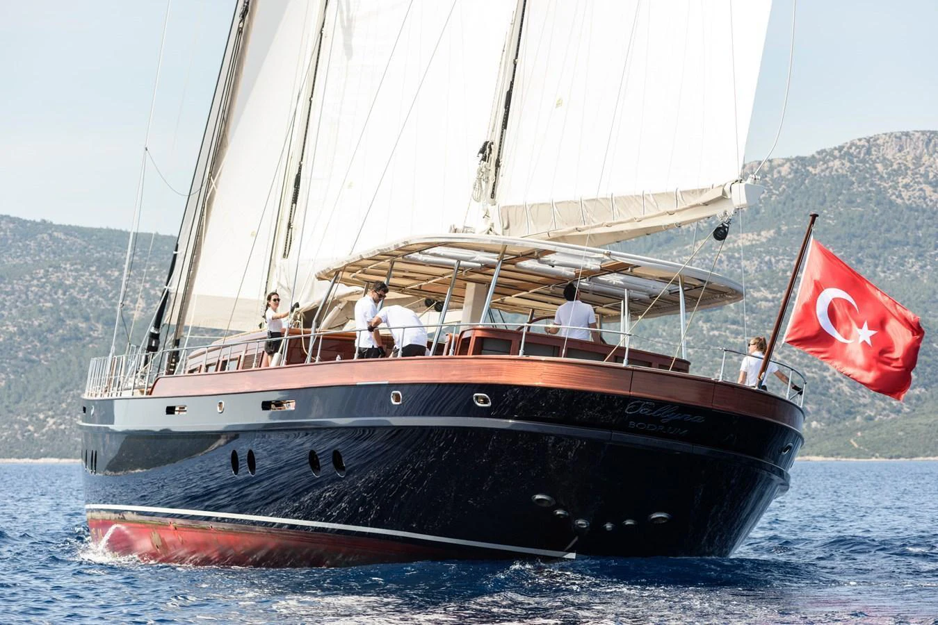 A sleek sailing yacht glides through the water, showcasing its elegant design and spacious deck. aboard SALLYNA Yacht for Sale