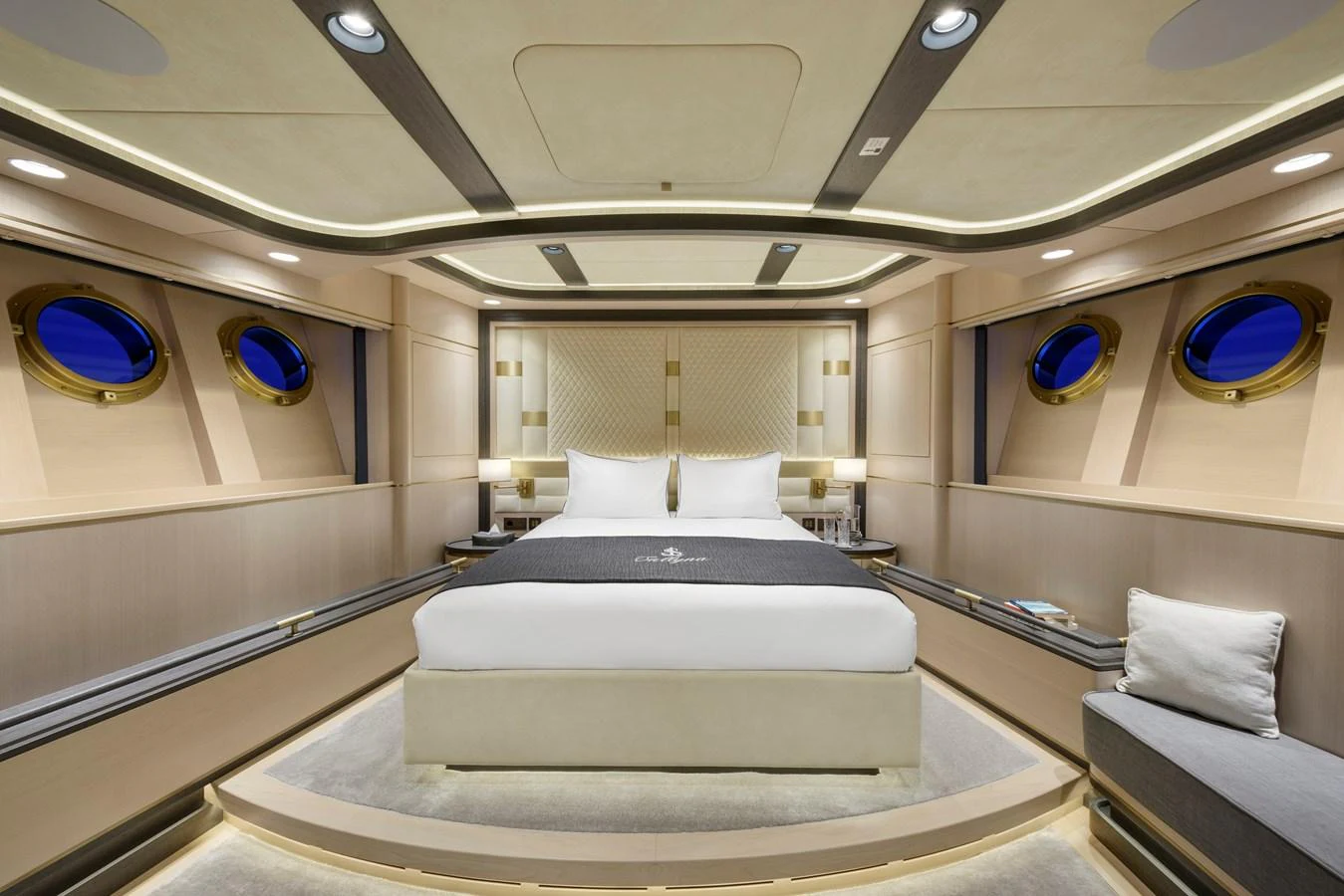 The master stateroom features a luxurious bed with elegant lighting and porthole windows offering a serene view. aboard SALLYNA Yacht for Sale