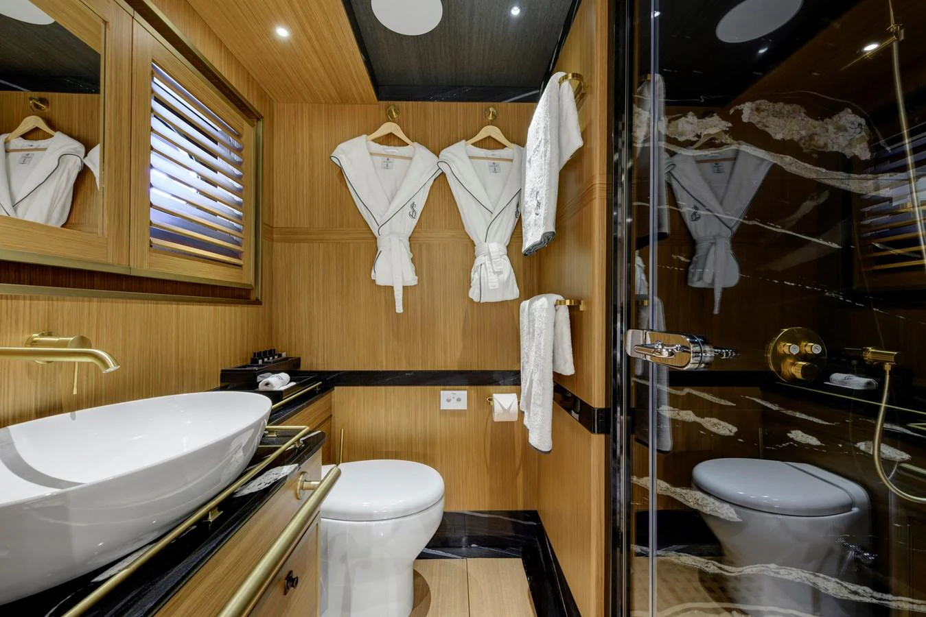 The bathroom features elegant wood paneling, a modern sink, and luxurious amenities. aboard SALLYNA Yacht for Sale