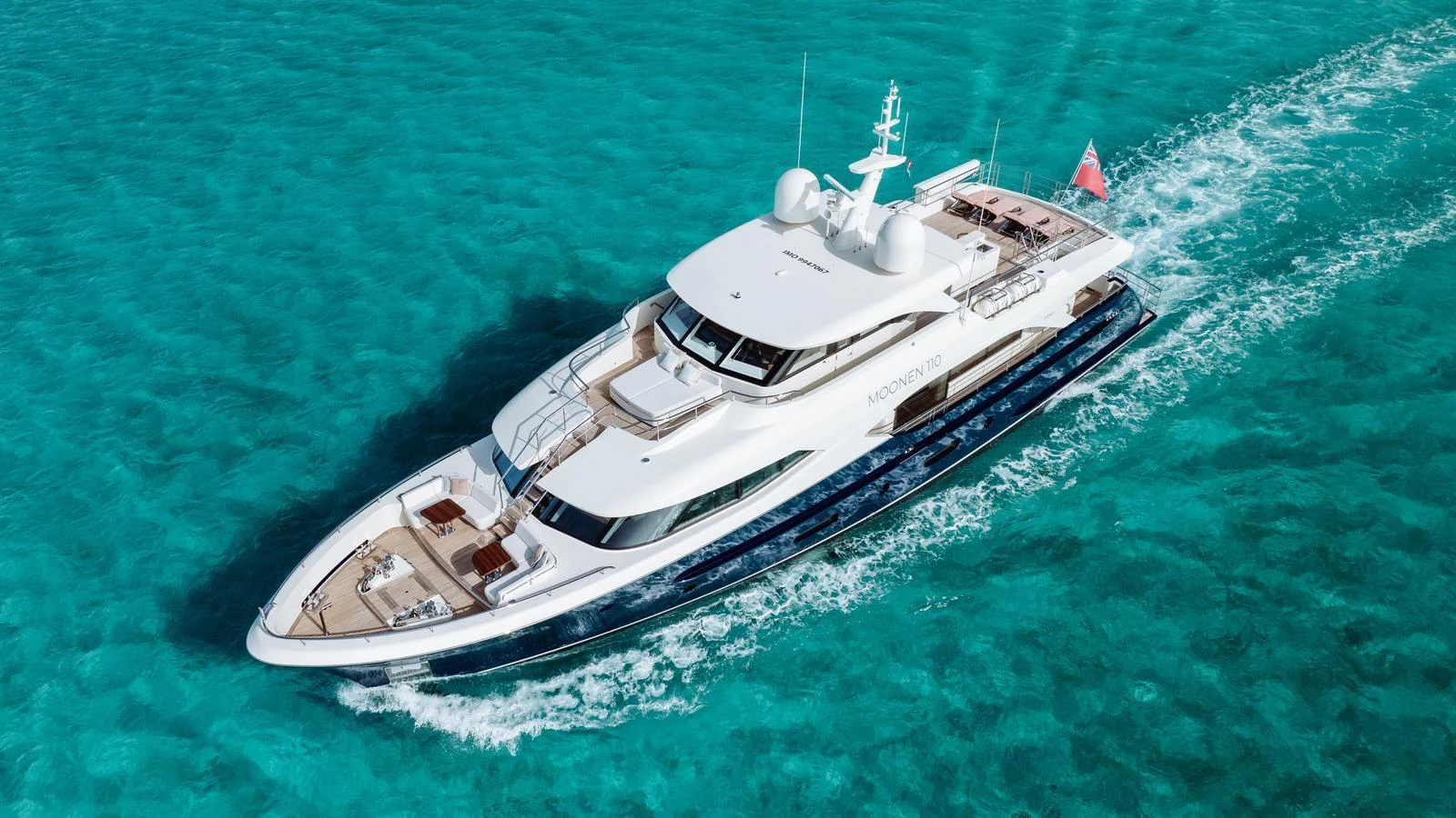 A luxurious yacht cruises through clear turquoise waters, showcasing its sleek design and spacious decks. aboard MIDNIGHT SAGA Yacht for Sale