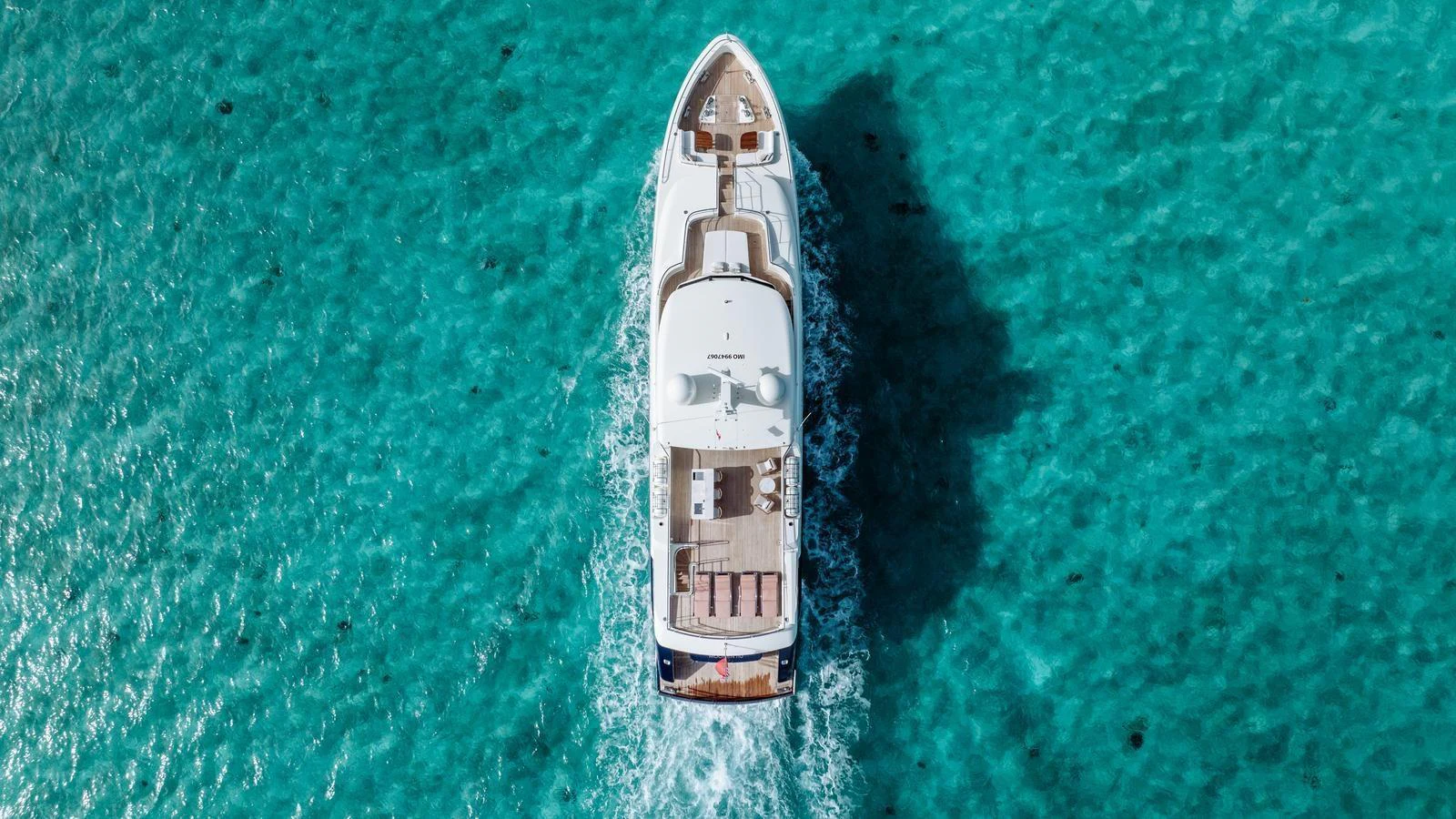 A stunning aerial view of a yacht cruising through crystal-clear turquoise waters. aboard MIDNIGHT SAGA Yacht for Sale