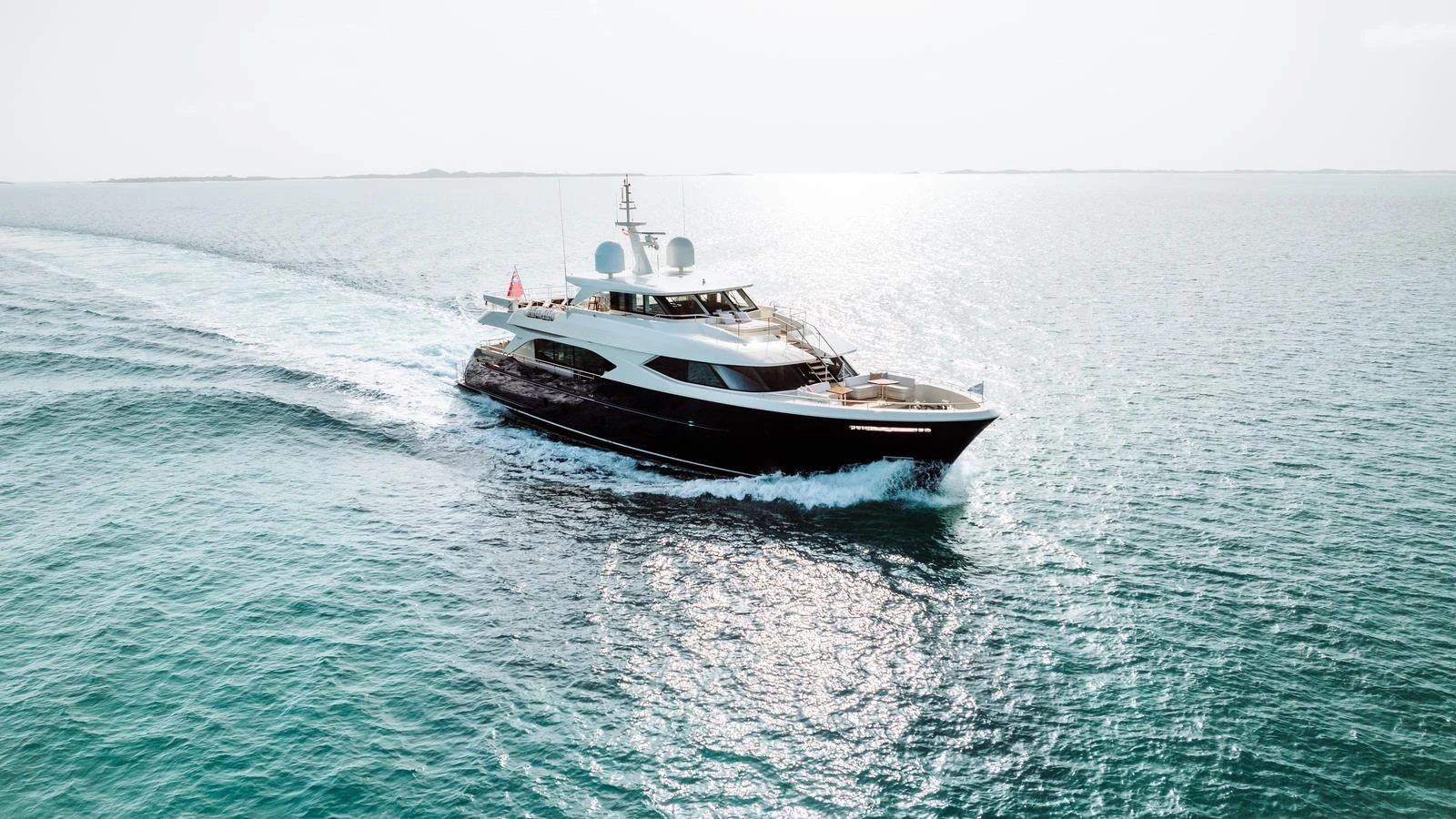 A sleek yacht cruises through calm, open waters under a clear sky. aboard MIDNIGHT SAGA Yacht for Sale