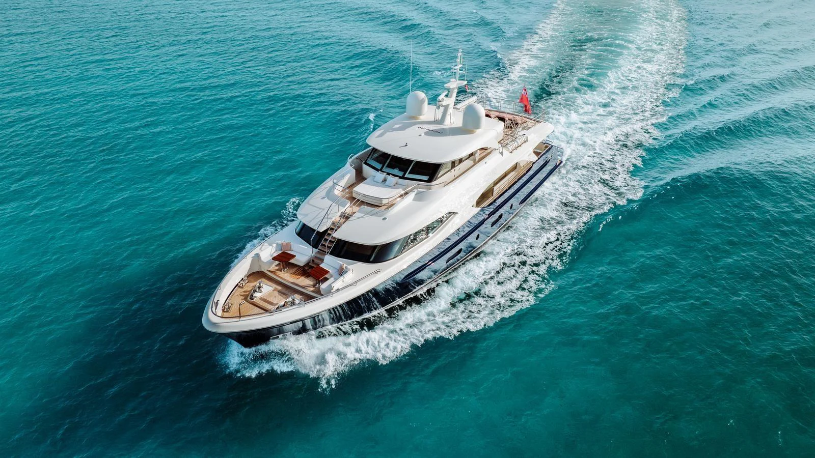 A luxurious yacht cruises through pristine turquoise waters, showcasing its sleek design and spacious deck. aboard MIDNIGHT SAGA Yacht for Sale
