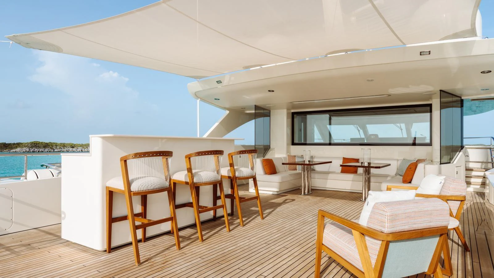 The aft deck features a stylish bar area with comfortable seating and a shaded lounging space. aboard MIDNIGHT SAGA Yacht for Sale