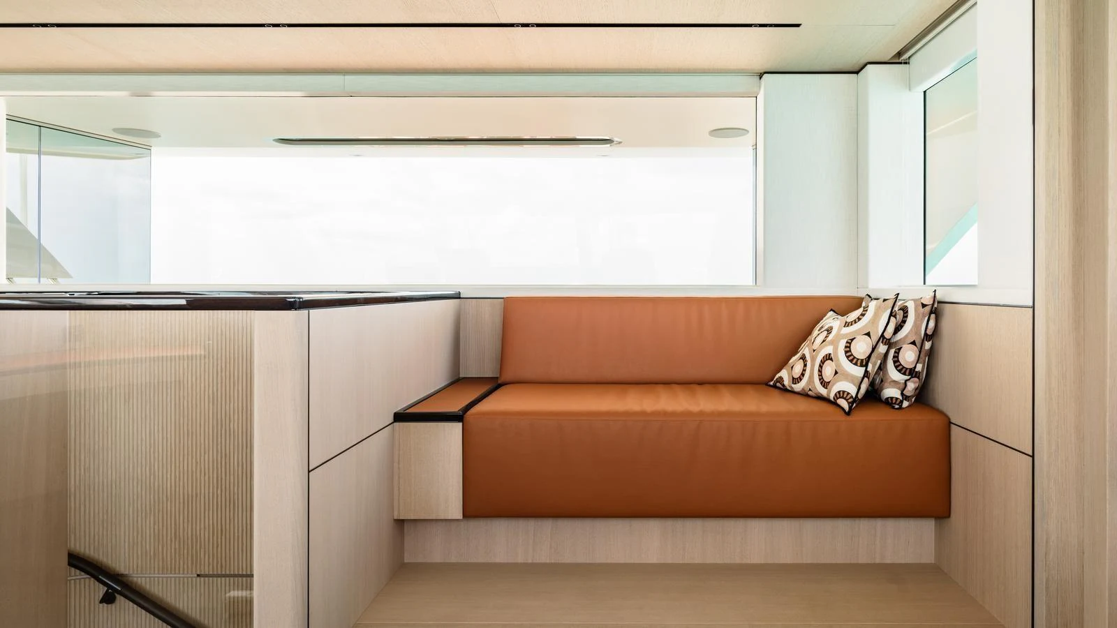 A stylish and modern interior seating area with a comfortable leather sofa and decorative pillows. aboard MIDNIGHT SAGA Yacht for Sale