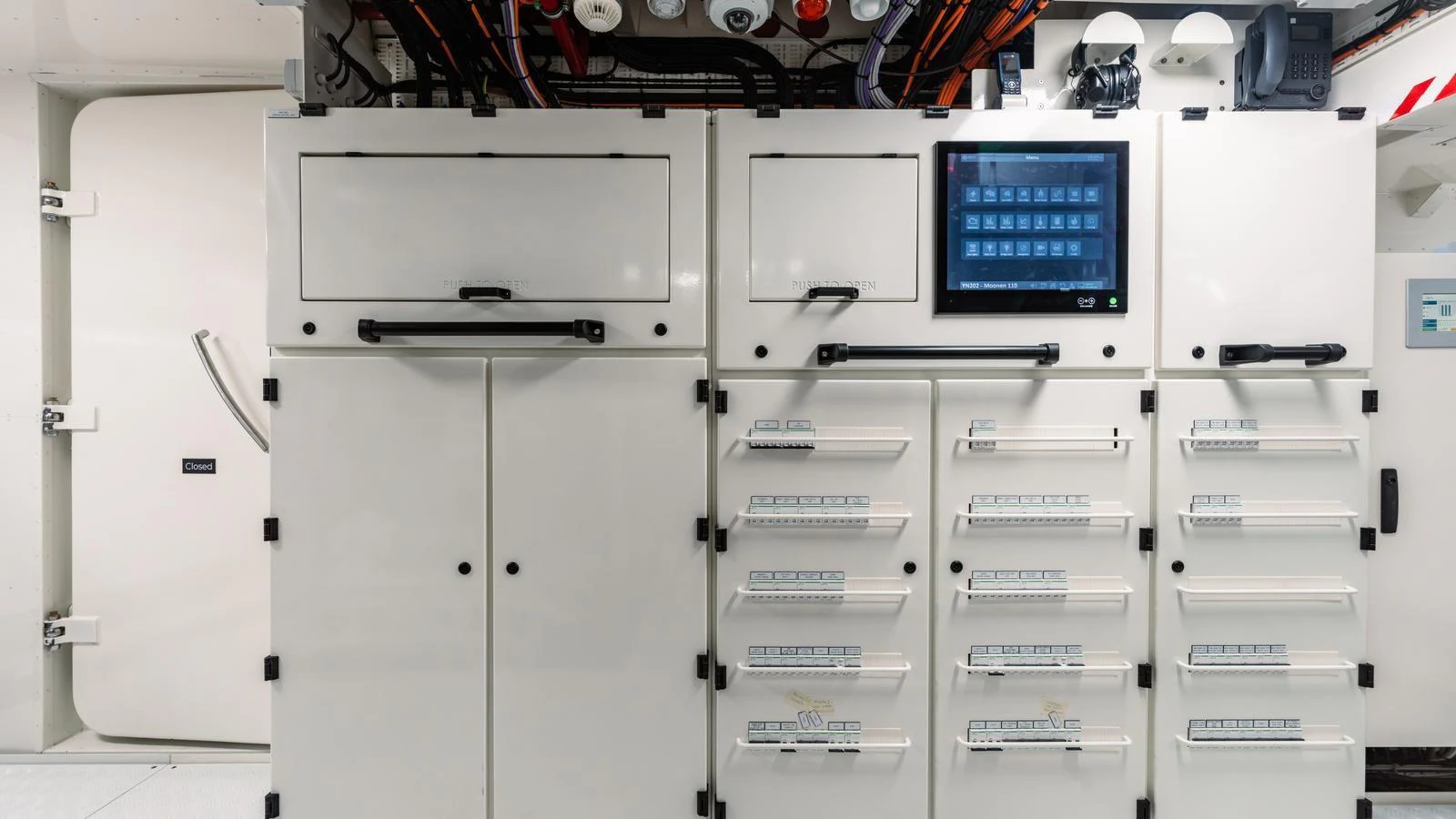 The image showcases a technical area of the yacht with control panels and storage compartments. aboard MIDNIGHT SAGA Yacht for Sale