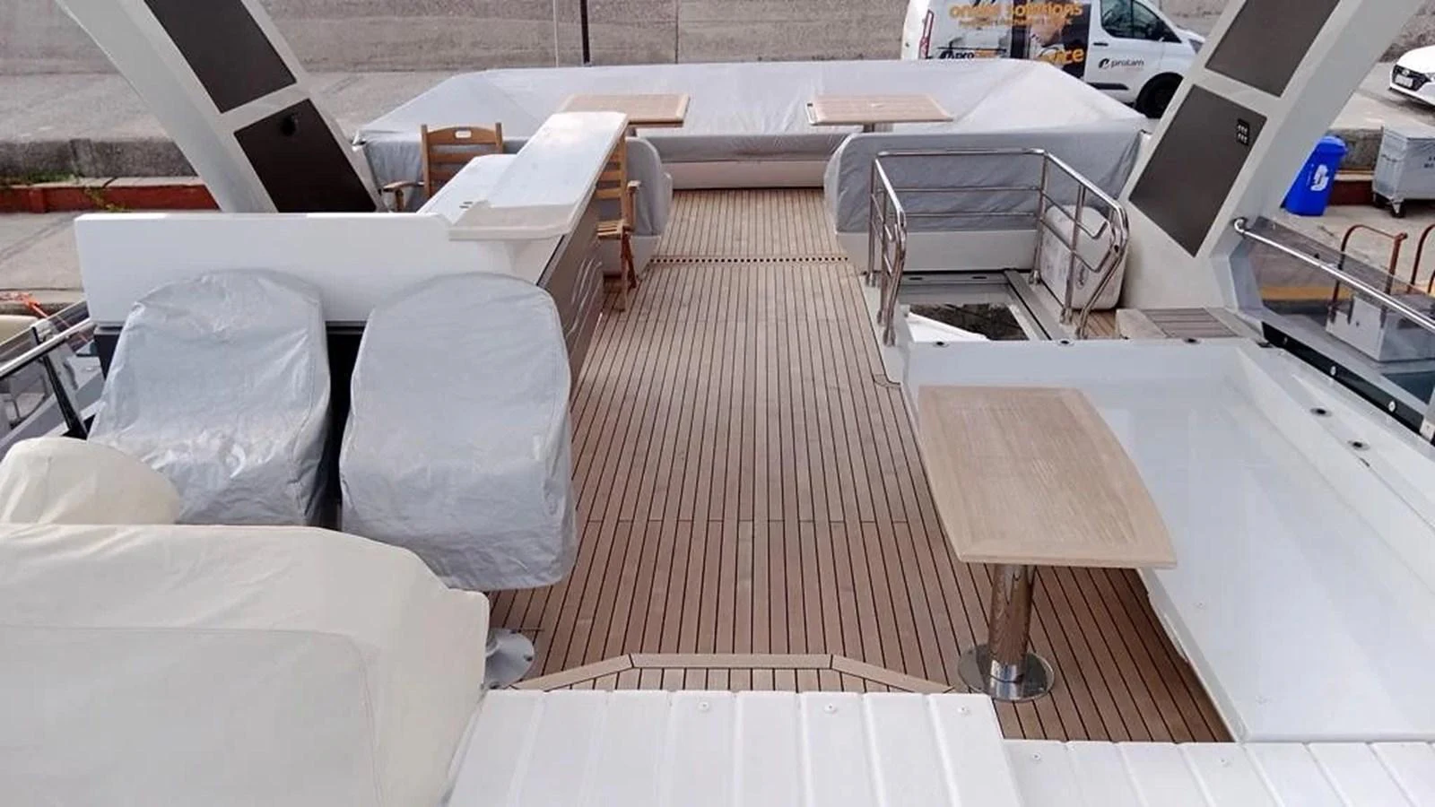 The flybridge features ample seating and dining areas with protective covers in place. aboard VIRTUS Yacht for Sale
