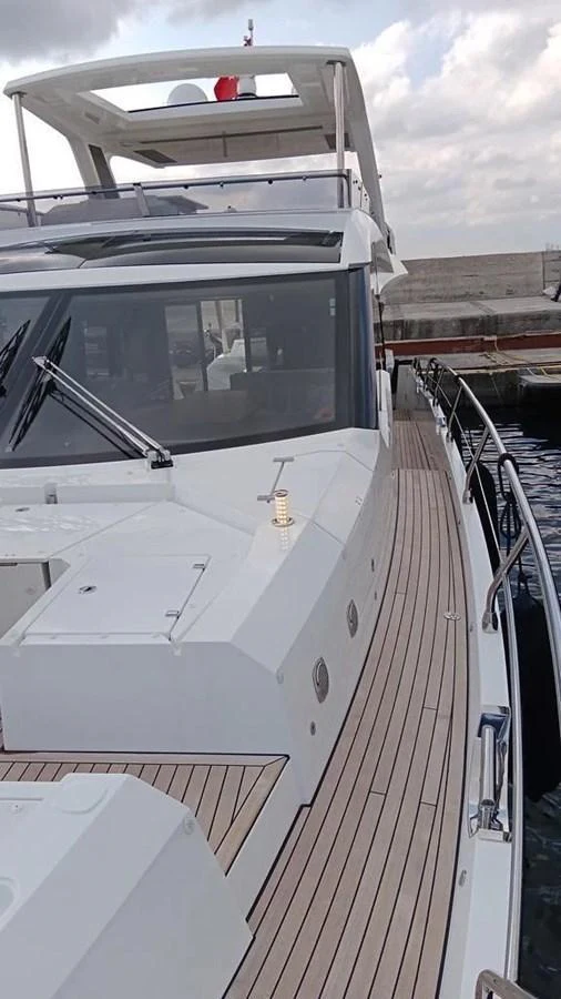 The yacht's sleek exterior features a spacious deck with modern design elements. aboard VIRTUS Yacht for Sale