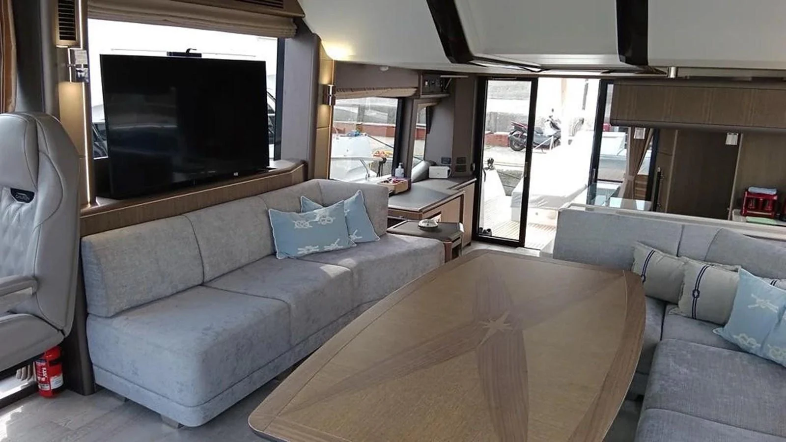 The salon features a spacious seating area with a large table and a flat-screen TV, offering a comfortable and stylish environment. aboard VIRTUS Yacht for Sale