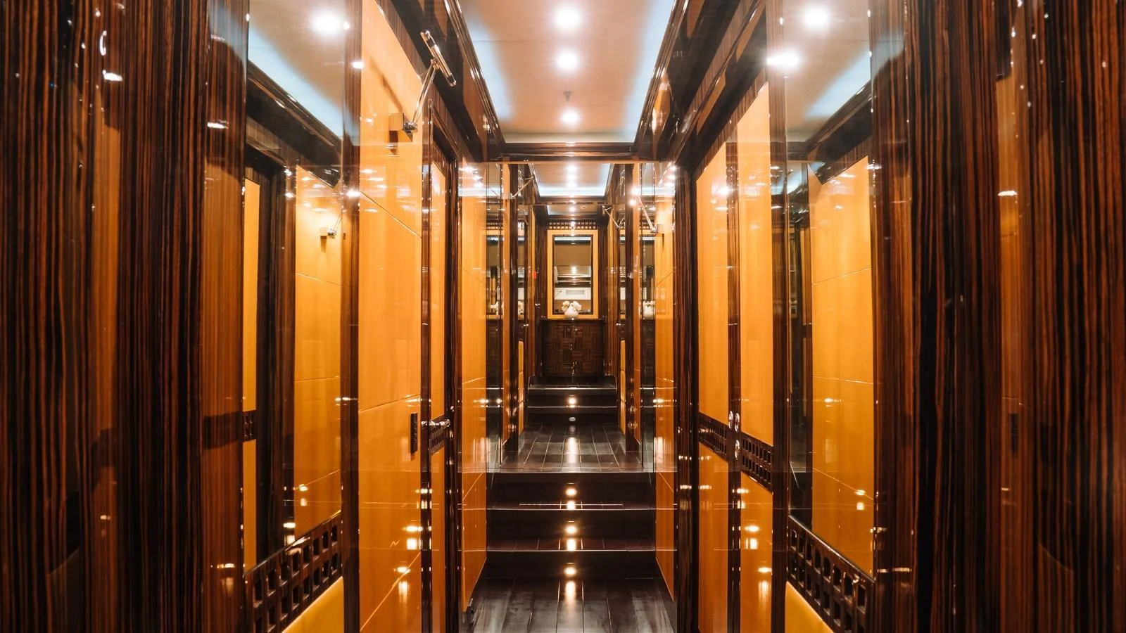 The yacht's interior hallway features luxurious wood paneling and ambient lighting. aboard SEA PEARL Yacht for Sale