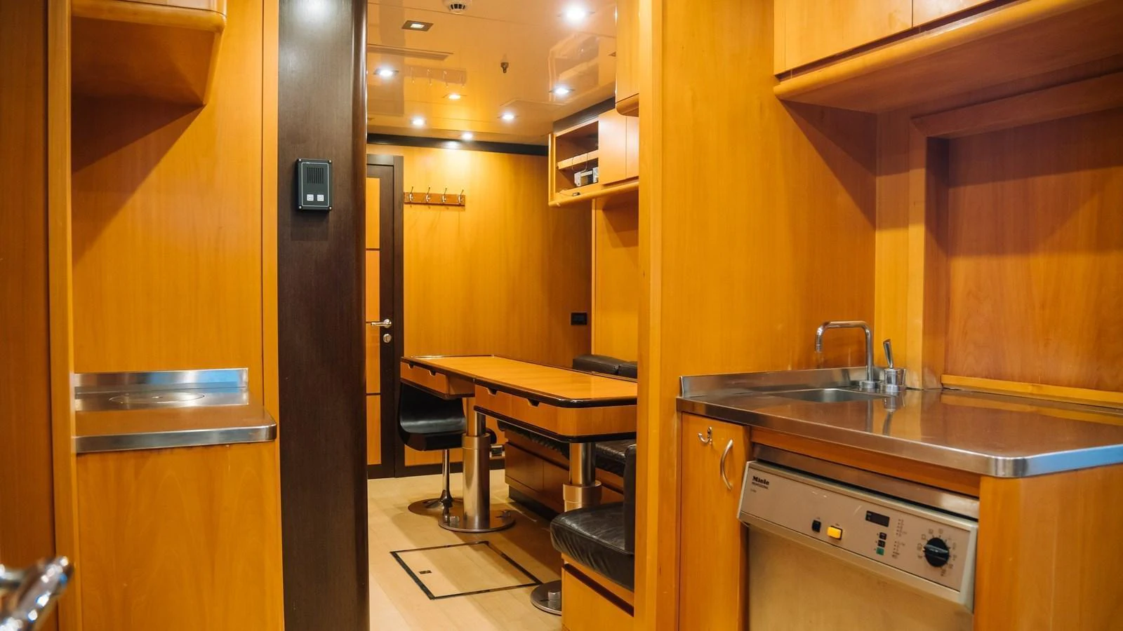 The yacht's galley features warm wooden cabinetry, a dining area, and modern appliances. aboard SEA PEARL Yacht for Sale