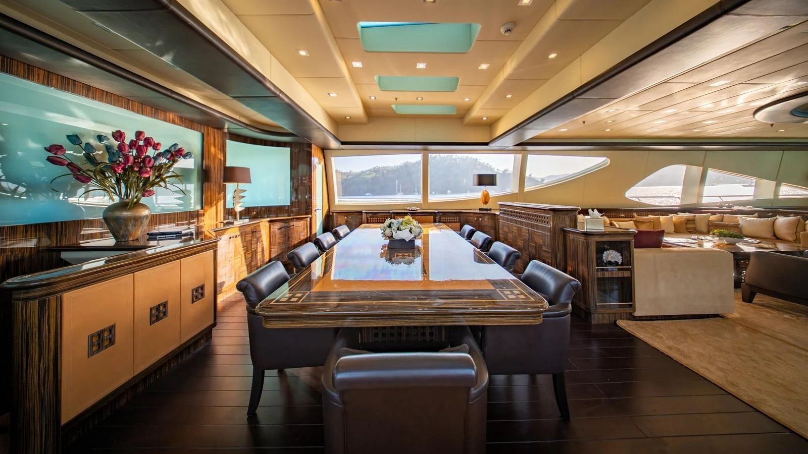 The yacht's dining area features elegant wood finishes, large windows, and luxurious seating. aboard SEA PEARL Yacht for Sale